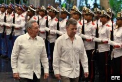 Raúl Castro (i) y el presidente de Colombia, Juan Manuel Santos (d), pasan revista a las tropas formadas para la ceremonia oficial de recibimiento 17 de julio de 2017.