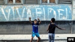 Dos niños juegan frente a una pintada alusiva al líder cubano Fidel Castro en una calle de La Habana.