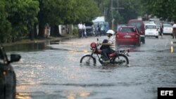 Un hombre conduce una motocicleta por una calle inundada el miércoles en La Habana