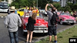 Turistas en La Habana se toman fotos sobre un "almendrón" americano de los años 50. El turismo ha permitido a la economía cubana salir en la primera mitad de 2017 de los números rojos en que terminó 2016.