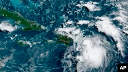 Esta imagen de satélite proporcionada por la Administración Nacional Oceánica y Atmosférica (NOAA) muestra una tormenta tropical Fred en el Caribe mientras pasa al sur de Puerto Rico y la República Dominicana.