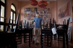 Gregory Biniowsy, canadiense copropietario del Nazdarovie restaurant posa en su estableciemiento cerrado durante el COVID-19.AP Photo/Ismael Francisco)