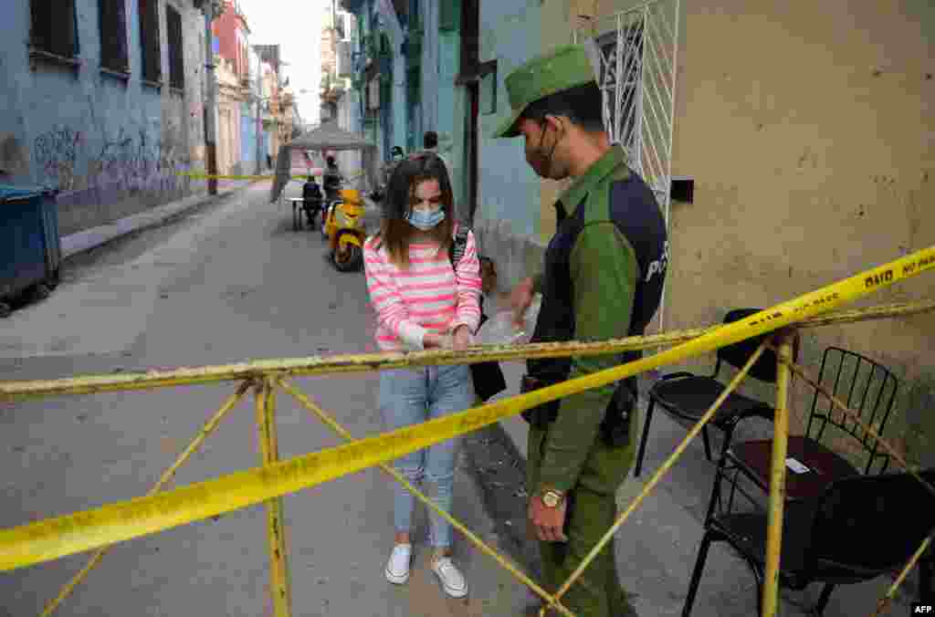 Un polic&#237;a vigila la entrada a un barrio con brote de coronavirus en La Habana. (YAMIL LAGE / AFP)