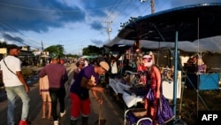 Un hombre barre la calle mientras los peregrinos cubanos participan en la procesión de San Lázaro en la iglesia El Rincón en La Habana el 16 de diciembre de 2024.