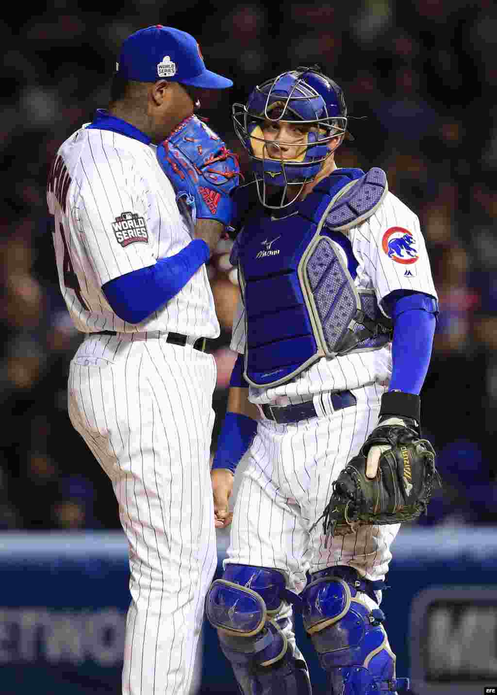 Aroldis Chapman (i) habla con el catcher Willson Contreras.