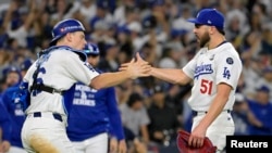 El pitcher de los Dodgers, Alex Vesia (51) y el catcher Will Smith (16) celebran el triunfo de este sábado frente a los Yankees. (Jayne Kamin-Oncea-Imagn Images vía Reuters)