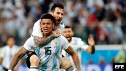 Marcos Rojo (frente) de Argentina celebra con Lionel Messi (arriba) el 2-1 ante Nigeria.