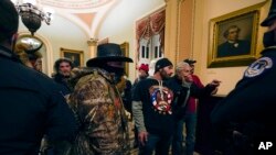 Manifestantes caminan por los pasillos del Capitolio de los Estados Unidos, en Washington, el 6 de enero. (AP/Manuel Balce Ceneta)