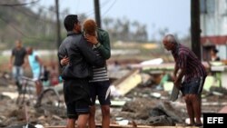 Cubanos buscan objetos entre los escombros dejadps por Matthew.