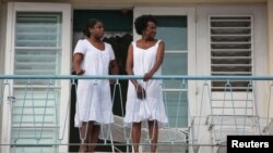 Mujeres observan desde una balcón una marcha contra la homofobia en La Habana. REUTERS/Alexandre Meneghini