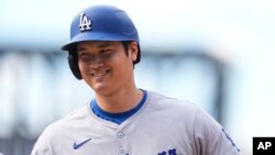 Shohei Ohtani, de los Dodgers de Los Ángeles, sonríe durante el juego d su equipo contra los Rockies de Colorado en Denver, el 29 de septiembre de 2024.