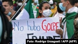 Una opositora al gobierno del presidente boliviano Luis Arce sostiene un cartel que dice "No fue un golpe, fue un fraude" mientras participa en una protesta contra el arresto de la expresidenta interina Jeanine Áñez y sus ex ministros. Foto: Rodrigo Urzagasti / AFP.