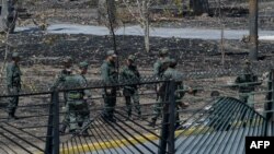 Miembros de la guardia nacional venezolana limpian las piedras y los escombros en la base militar de La Carlota en Caracas el 2 de mayo de 2019.