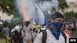 Un joven lanza mortero durante una multitudinaria marcha en apoyo a los estudiantes nicaragüenses.