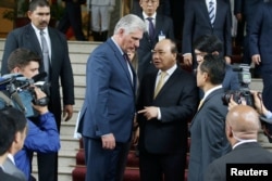 Anido Cuesta, detrás de su padrastro en una reunión con el primer ministro de Vietnam, Nguyen Xuan Phuc, en Hanoi, Vietnam, el 9 de noviembre de 2018. Luong Thai Linh/Pool vía REUTERS