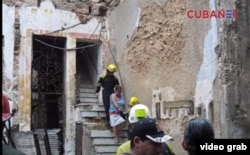 Los bomberos ayudadn a evacuar a los sobrevivientes de un derrumbe en la calle Villegas de La Habana Vieja.