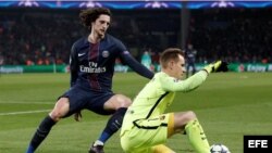 El portero del Barcelona Marc-Andre Ter Stegen (d) disputa el balón con adrien Rabiot (i), del París Saint Germain.