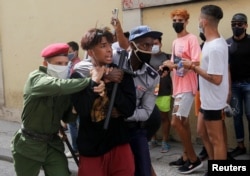 Policías detienen a un menor durante las protestas del 11 de julio de 2021 en La Habana. REUTERS / Stringer