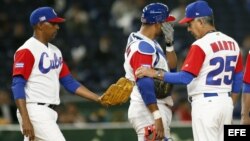 El entrenador de la selección cubana Carlos Martí (d) pasa la bola al receptor Jonder Martínez (i) en el partido entre Cuba y Holanda del IV Clásico Mundial de Béisbol.