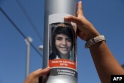 Una mujer coloca la imagen de una joven desaparecida en un poste de Ciudad Juárez. (Archivo)