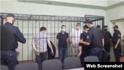 Ihar Losik (camiseta oscura), Syarhey Tsikhanousky (camiseta blanca) tras ser conducidos a la jaula de los acusados en la apertura de su juicio a puerta cerrada en un centro de detención en Homel, Bielorrusia. Foto de archivo, 24 de junio de 2021.