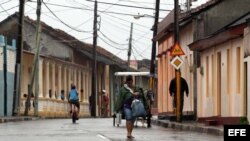 Una mujer camina por las calles de la ciudad de Baracoa, hoy, martes 04 de octubre, en Guantánamo (Cuba). El "extremadamente peligroso" huracán de categoría 4 Matthew.