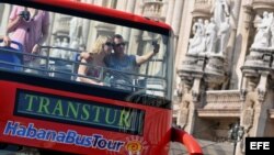 Una pareja de turistas se toma una foto en un bus en La Habana.