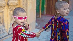 Dos niños uigures caminan por una calle en Yarkand, Región Autónoma Uigur de Xinjiang, China.