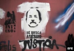 Vista de una imagen del presidente Daniel Ortega pintada en una pared junto a la frase "Se busca asesino".