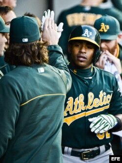 El jugador de los Atléticos Yoenis Céspedes (d) es felicitado por su compañero John Jaso (i) tras anotar un cuadrangular ante los Medias Blancas el jueves 6 de junio de 2013, en el US Cellular Field de Chicago, Illinois (EE.UU.).