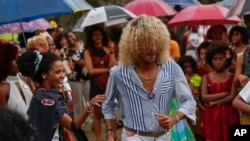 Los espectadores reaccionan ante un participante mientras camina por la pasarela durante un desfile de moda de peinados afro en La Habana, Cuba, el sábado 31 de agosto de 2024. (Foto AP/Ramon Espinosa)