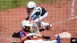 El cubano Roberto Martínez (6) es eliminado por el receptor australiano Isaac Meighan cuando intentaba anotar durante la quinta entrada de un juego de béisbol en el torneo de la Serie Mundial de Pequeñas Ligas en South Williamsport, Pensilvania, el sábado 19 de agosto de 2023. ( Foto AP/Tom E. Puskar)