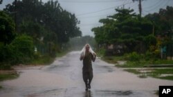 Un hombre usa un trozo de plástico como protección ante las fuertes lluvias provocadas por el huracán Helene, en Batabano, Cuba, el miércoles 25 de septiembre de 2024. (Foto AP/Ramon Espinosa)