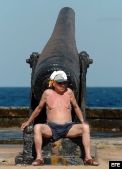 Un turista toma el sol en La Habana junto a un viejo cañón. EFE