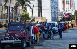 Los conductores hacen cola para llenar sus tanques de gasolina cerca de una gasolinera en La Habana el 11 de diciembre de 2024. YAMIL LAGE / AFP