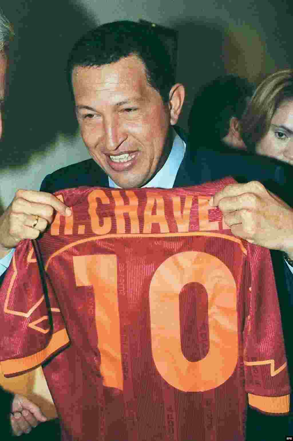 El presidente de Venezuela, Hugo Ch&aacute;vez, muestra una camiseta de b&eacute;isbol con su nombre, que le entreg&oacute; un compatriota a su llegada a la sede de la CEOE en octubre de 1999, donde asisti&oacute; a una reuni&oacute;n con empresarios espa&ntilde;oles y venezolanos.