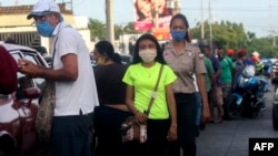 Personas se protegen con mascarillas en las calles de Maracaibo, Venezuela. Luis BRAVO / AFP)