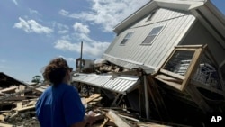 Laurie Lilliott inspecciona lo que queda de su casa después de que el huracán Helene pasara por la zona de Dekle Beach, Florida, en el condado rural de Taylor, el viernes 27 de septiembre de 2024. (Foto AP/Kate Payne)