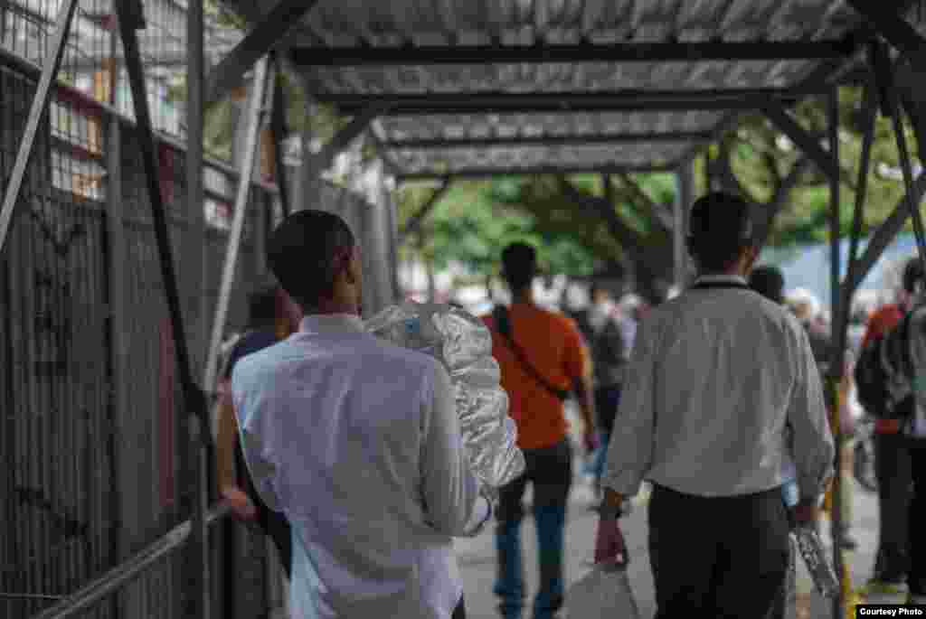 Trabajadores del Banco NAcional de Crédito, regalan botellas de agua potable a manifestantes en la Avenida Francisco de Miranda. (Foto: Juan Pablo Arraez)