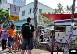 Cubanos a las puertas de una casa de cambio.