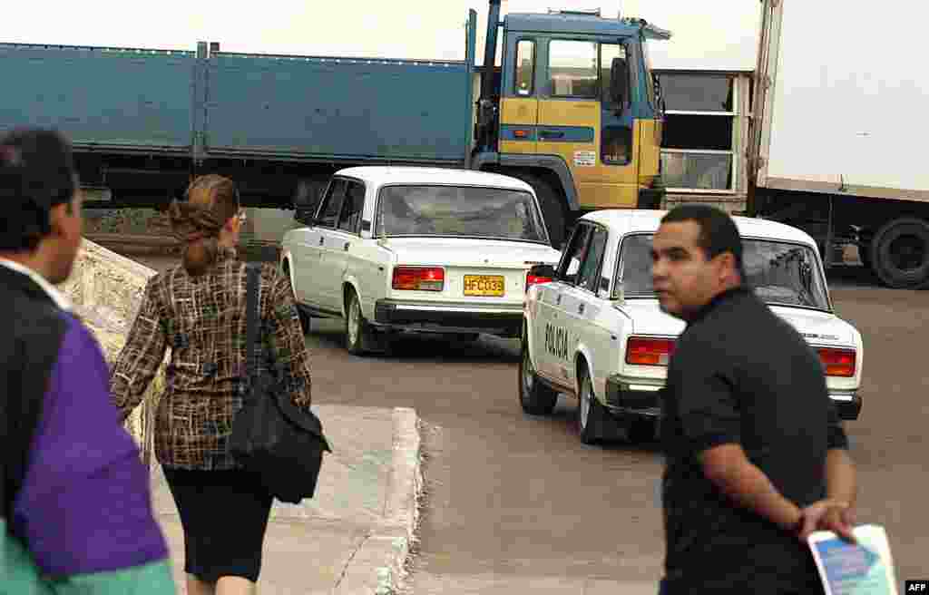 Autos de la policía política cubana arriban con disidentes al Tribunal Supremo de La Habana, el 03 de abril de 2003, donde serán juzgados por el delito de atentar contra la seguridad del Estado. 