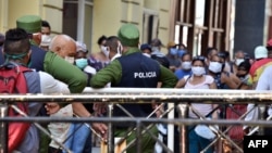 La policía controla a una multitud en fila para comprar alimentos en un mercado de La Habana. (ADALBERTO ROQUE / AFP)