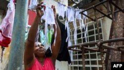 Una mujer tiende nasobucos preparados por ella misma para distribuir entre vecinos del Vedado (Foto: Adalberto Roque/AFP).