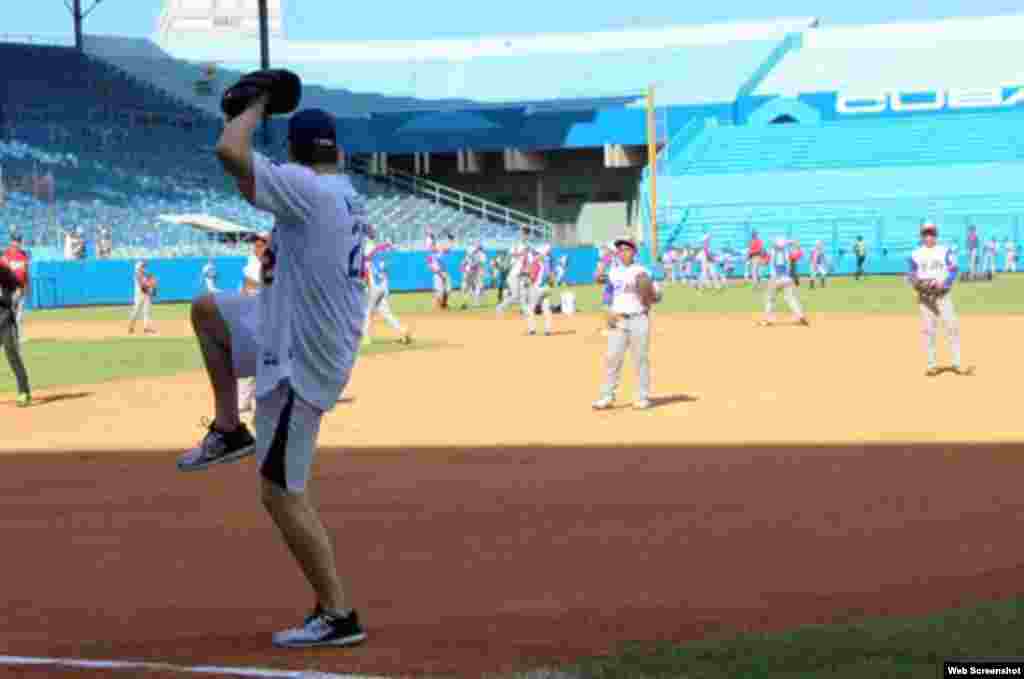 Clayton Kershaw, pitcher zurdo de los Dodgers de Los Ángeles, muestra a los niños cubanos los movimientos que él hace para lanzar.