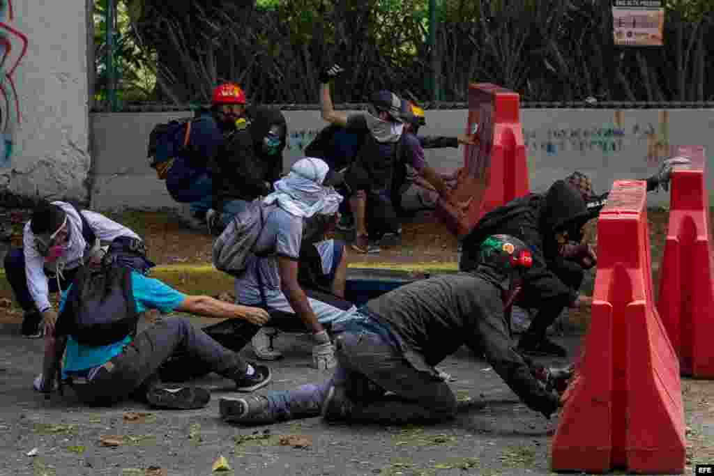 Un manifestante recibe ayuda de sus compañeros tras resultar herido durante un enfrentamiento con policías antimotines hoy, jueves 4 de mayo de 2017, en Caracas (Venezuela). Los cuerpos de seguridad dispersaron con gases lacrimógenos la manifestación de e