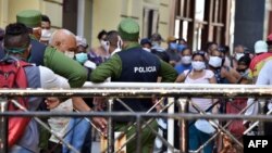 Cubanos se aglomeran en un mercado de La Habana, bajo la vigilancia de agentes de la policía, para comprar alimentos, el 12 de abril del 2020.