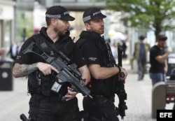 Agentes de policía británicos permanecen en guardia en el centro de Manchester, Reino Unido.