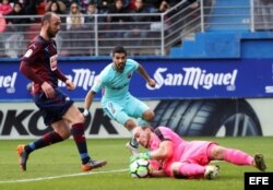 El portero del EIbar Marko Dmitrovic (d) para el balón ante el delantero uruguayo del FC Barcelona Luis Suárez (c).