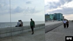 Dos hombres caminan junto a la obra "Happily Ever After", de Rachel Valdés Camejo, colocada en el malecón de La Habana. Como parte de la XI Bienal de La Habana. Archivo.