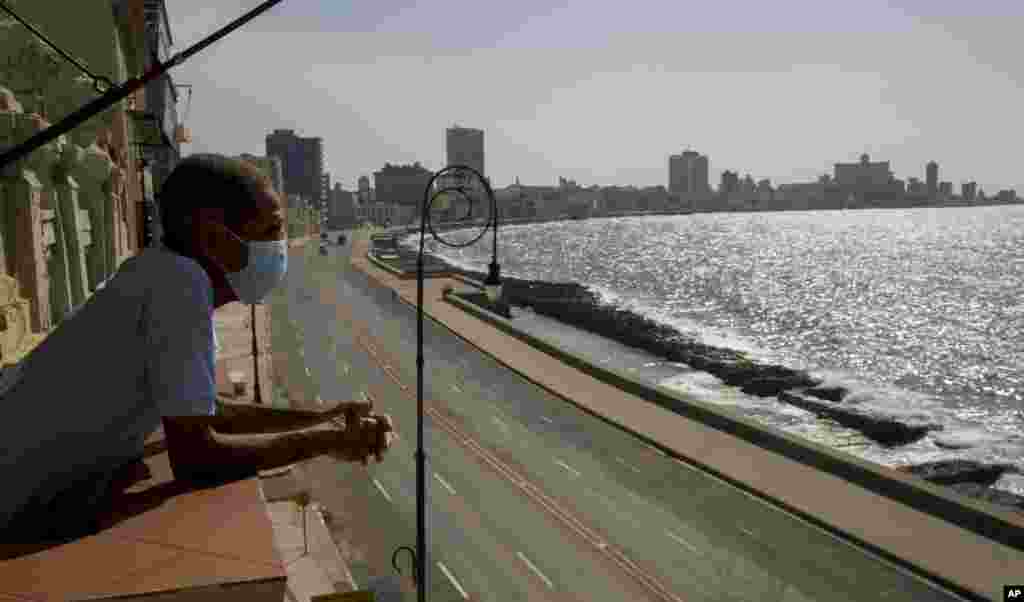 El trabajador Julio Diago mira la carretera vac&#237;a a lo largo del malec&#243;n desde el restaurante Nazdarovie, que est&#225; cerrado por la cuarentena. (AP/Ismael Francisco)